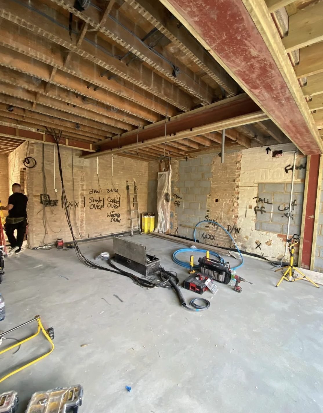 First fix wiring running through floor joists with circuits chalked on brickwork