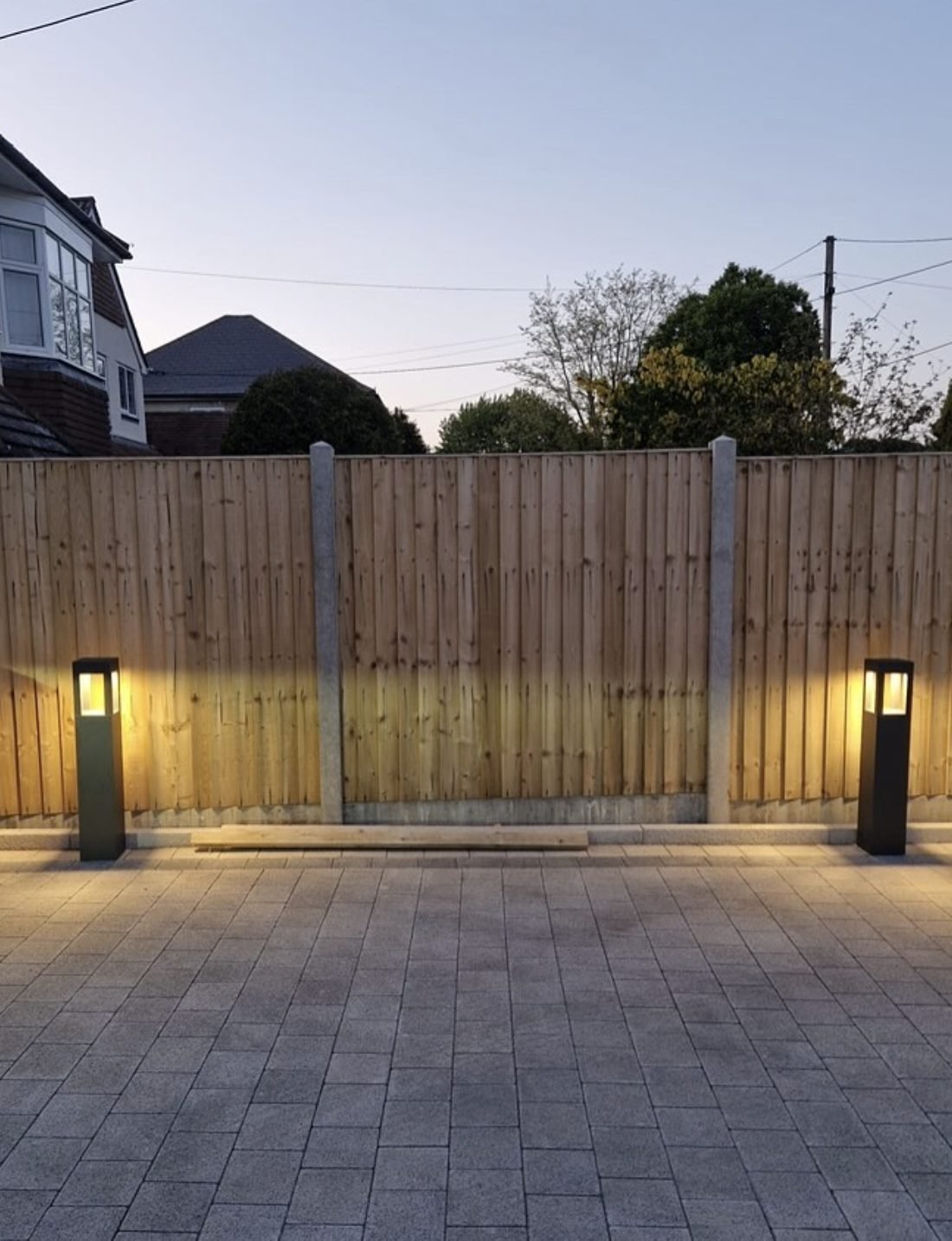 Bollard lights illuminating a block paved driveway at dusk in Leeds